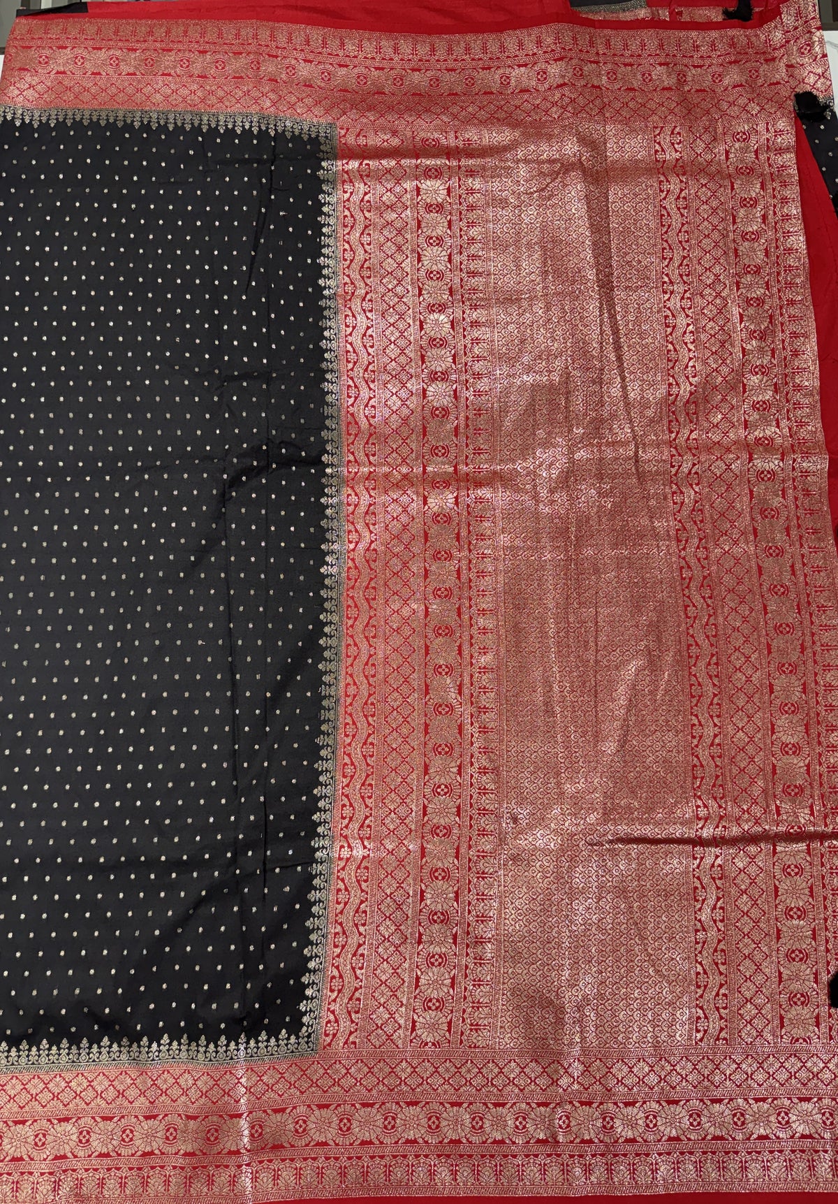 Banarasi Fancy Saree Black Colored Complemented with a Red Zari Border.