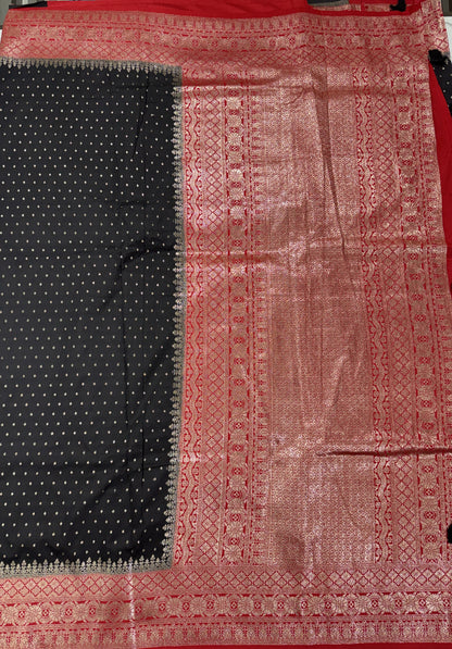 Banarasi Fancy Saree Black Colored Complemented with a Red Zari Border.
