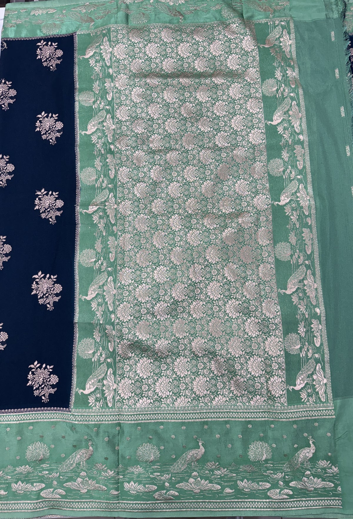 Banarasi Fancy Saree Dark Teal Blue Blue Colored Complemented with a Light Green Zari Border.